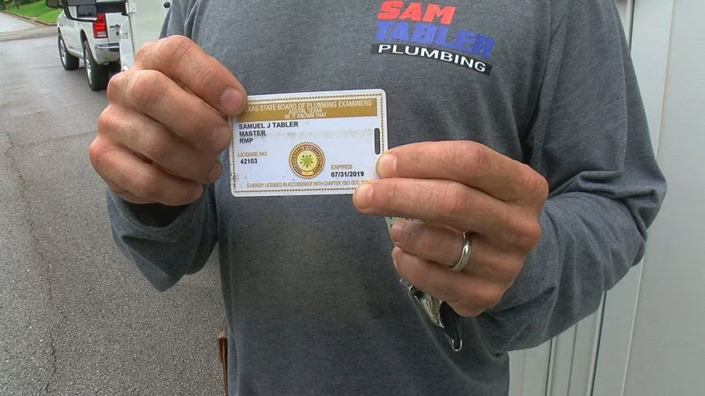 Plumber in Texas showing off his state issued plumbing license card.